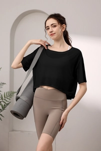 Detail eines lockeren schwarzen T-Shirts und taupefarbenen Yoga-Biker-Shorts für Damen