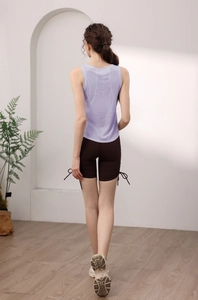 Vista dettagliata del retro di un top da yoga lilla senza maniche e pantaloncini marroni