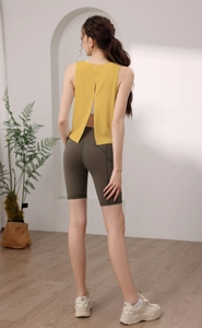 Dettaglio di un gilet sportivo giallo con spacco posteriore che mostra il reggiseno yoga