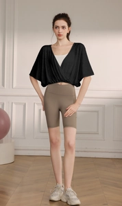 Close-up of black jacquard batwing sleeve sports top with V-neck cross design for yoga