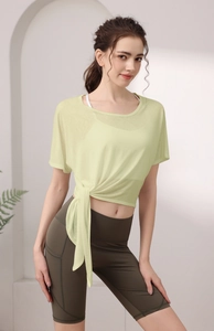 Détail d'un haut de yoga jaune clair avec nœud latéral et short de cyclisme vert