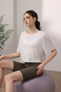Détail du t-shirt de yoga en modal blanc et du short de cyclisme vert foncé