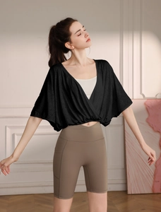 Detail of black jacquard yoga cover-up featuring batwing sleeves and elastic hem design