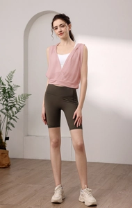 Haut de yoga rose sans manches à capuche et short de fitness vert olive sur modèle