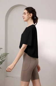 Detail eines Sportsets mit schwarzem Oberteil und khakifarbener Radlerhose mit Seitentaschen