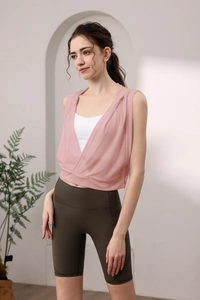 Débardeur de yoga à capuche rose sur soutien-gorge de sport et short cycliste vert olive