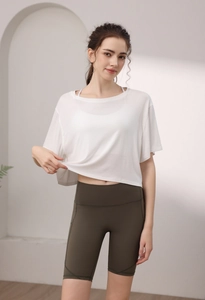 Détail d'un t-shirt de yoga en modal blanc ample et d'un short de cyclisme vert