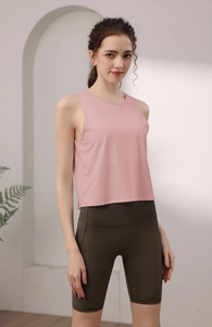 Dettaglio del gilet sportivo in nylon rosa senza maniche e pantaloncini da yoga verdi