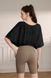Detail of black jacquard batwing sleeve sports top and high-waist biker shorts
