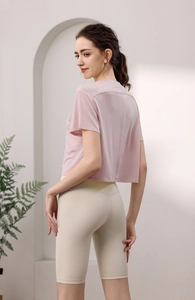Detailansicht eines rosa Tencel-Sport-T-Shirts und High-Waist-Radlerhosen von hinten