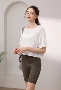 Détail du short de cyclisme taille haute vert olive et du crop top blanc de yoga