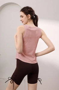 Dettaglio del gilet sportivo in Lyocell rosa e pantaloncini marroni con fiocchi laterali