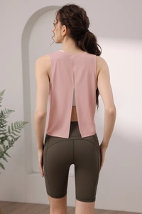 Vista posteriore del gilet sportivo rosa con design a spacco e pantaloncini verdi
