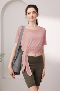 Détail du haut de sport en maille tencel rose avec nœud latéral et short cycliste