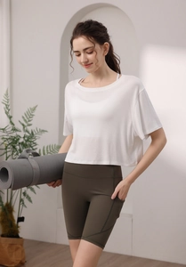 Détail du haut de yoga blanc en modal et short taille haute vert olive avec poche latérale