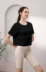 Detail von hochwertigem schwarzen Tencel-T-Shirt und beigen Yoga-Shorts am Modell
