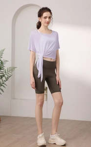 Vue détaillée du haut de yoga lilas avec nœud latéral et short de cyclisme taille haute