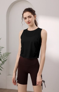 Detail of slim-fit black yoga tank top paired with brown drawstring sports shorts