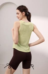Dettaglio della canotta da yoga incrociata e pantaloncini marroni con fiocchi laterali