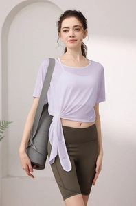 Détail d'un haut de yoga en maille lavande noué sur le côté et d'un soutien-gorge blanc
