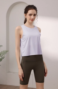 Dettaglio della canotta da yoga in nylon lilla e dei pantaloncini fitness verde oliva a vita alta