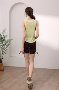 Dettaglio del retro di un gilet sportivo verde chiaro da donna e pantaloncini marroni