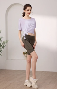 Vue détaillée d'un haut de yoga en maille lilas avec nœud latéral et short de cyclisme olive