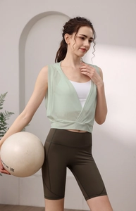 Détail d'une tenue de yoga pour femme avec un haut à capuche vert clair et un short cycliste