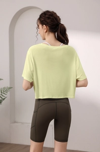 Vue de dos d'un haut court de yoga ample en modal jaune pâle, tissu léger et respirant