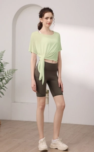 Détail du haut de yoga en tencel vert clair avec lien à la taille et short cycliste olive