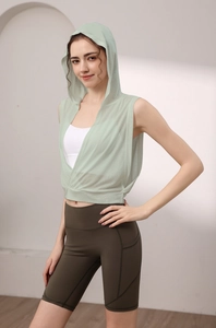 Détail du haut de yoga à capuche vert menthe sur soutien-gorge de sport et short olive