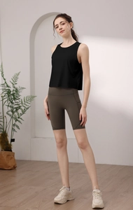 Canotta sportiva da donna in nylon nero abbinata a pantaloncini a vita alta verde oliva