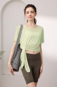 Détail du haut de sport vert clair avec nœud latéral élégant et texture en maille fine