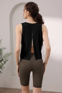 Dettaglio del gilet sportivo in nylon con spacco posteriore e pantaloncini a vita alta