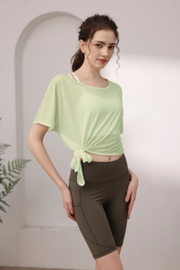 Détail du haut de yoga en maille ample avec nœud à la taille et short de cyclisme