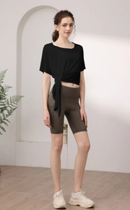 Détail d'un haut de yoga ample avec nœud à la taille et short de cyclisme vert olive