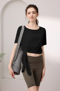 Détail du haut de yoga noir ample avec nœud latéral et tissu en tencel respirant