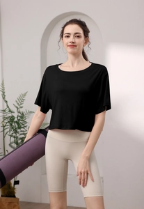 Détail mannequin portant haut court en modal noir et short de yoga taille haute beige