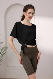 Détail du haut de yoga noir noué et du short de fitness olive à taille haute