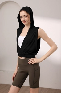 Détail du gilet de yoga à capuche noir avec ourlet croisé et short de cyclisme