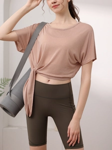 Haut de yoga rose ample avec nœud latéral et short de fitness vert olive