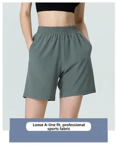 Detail of high-waist grey-green athletic shorts with loose A-line fit and side pockets