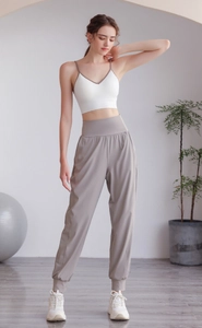 Dettaglio dei pantaloni sportivi a vita alta color talpa in tessuto morbido e fluido