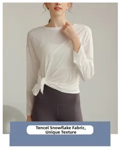 Détail du haut de sport blanc en tencel avec nœud latéral et texture unique ajourée