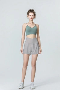 Détail du short de sport gris taille haute et de la brassière côtelée vert sauge