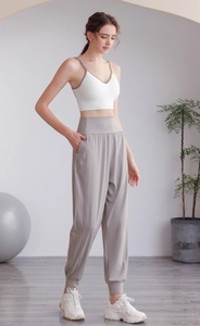 Dettaglio dei pantaloni fitness larghi a vita alta con tasche laterali e polsini a coste