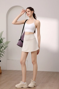 Detail of high-waisted white tennis skirt with side pockets and a matching sports bra