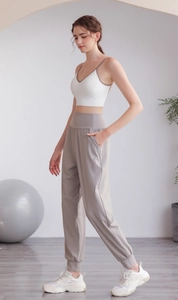 Dettaglio dei pantaloni da yoga grigi in nylon a vita alta con tasche per il fitness