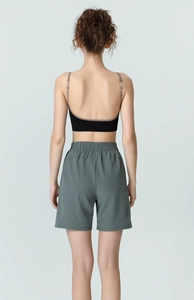 Detail of high-waisted gray-green sports shorts and a black ribbed tank top for fitness