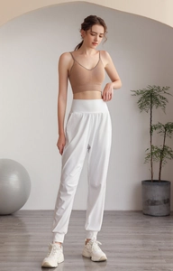 Vista completa dei pantaloni da yoga bianchi a vita alta con reggiseno sportivo caffè
